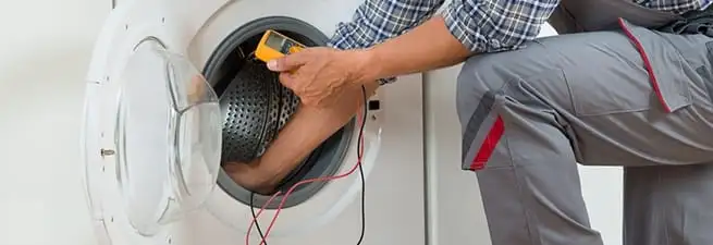 Dryer repair technician inspecting and repairing a clothes dryer in Cedar Rapids, IA