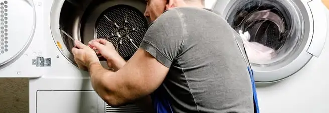 Dryer repair technician fixing a clothes dryer drum in Cedar Rapids, IA