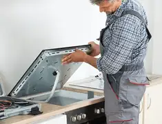 Appliance repair technician installing a built-in cooktop in Cedar Rapids, IA