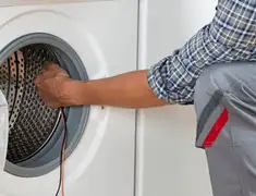 Dryer repair technician diagnosing and servicing a clothes dryer in Cedar Rapids, IA