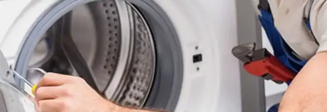 Appliance technician repairing a clothes dryer drum and internal parts in Cedar Rapids, IA