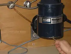 Garbage disposal repair technician tightening the mounting ring under a sink in Cedar Rapids, IA