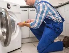 Washing machine repair technician servicing a front-load washer in Cedar Rapids, IA