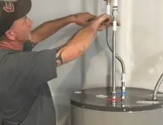 Water heater repair technician tightening supply line connections in Cedar Rapids, IA